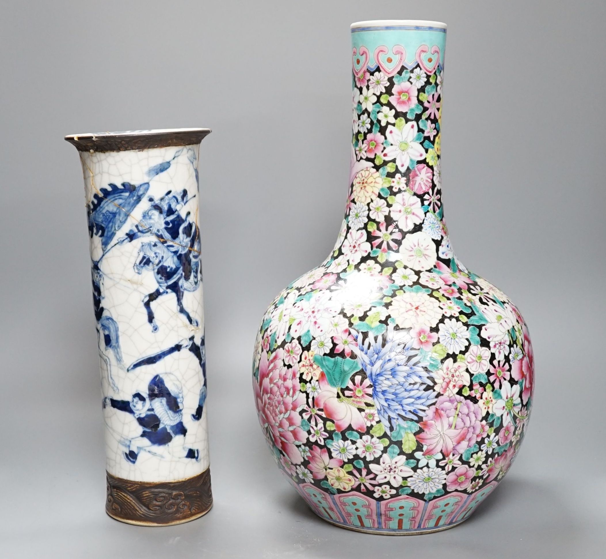 An early 20th century Chinese famille rose thousand flowers bottle vase (restored) together with a Chinese blue and white crackle glazed sleeve vase (a.f)., tallest 40cm